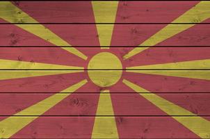 Macedonia flag depicted in bright paint colors on old wooden wall. Textured banner on rough background photo