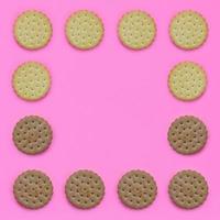 Pattern of a brown biscuits on a pink background. Trendy minimal concept of food and dessert. Abstract flat lay, top view photo