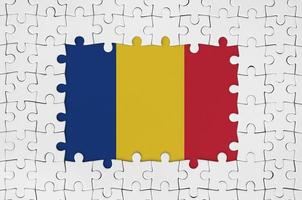 bandera rumana en el marco de piezas de un rompecabezas blanco con la parte central faltante foto