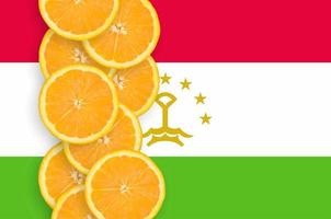 Tajikistan flag and citrus fruit slices vertical row photo