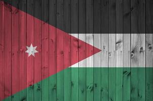 Jordan flag depicted in bright paint colors on old wooden wall. Textured banner on rough background photo