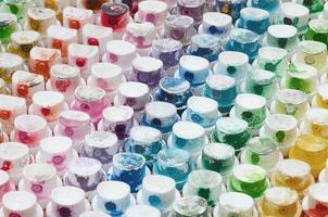 un patrón de muchas boquillas de un rociador de pintura para dibujar graffiti, manchado en diferentes colores. las tapas de plástico están dispuestas en muchas filas formando el color del arco iris foto