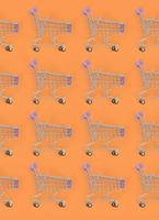 Shopping addiction, shopping lover or shopaholic concept. Many small empty shopping carts perform a pattern on a pastel colored paper background. Flat lay composition, top view photo