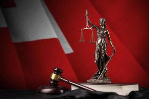 Tonga flag with statue of lady justice, constitution and judge hammer on black drapery. Concept of judgement and guilt photo