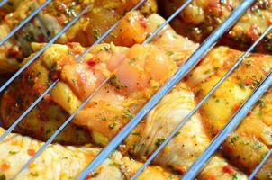 Marinated chicken legs on hot BBQ charcoal field grill photo