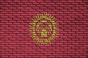 Kyrgyzstan flag is painted onto an old brick wall photo