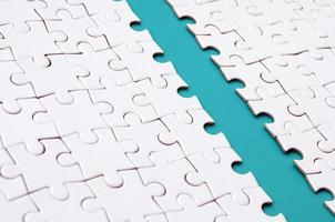 The blue path is laid on the platform of a white folded jigsaw puzzle. Texture image with copy space for text photo