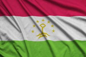 Tajikistan flag  is depicted on a sports cloth fabric with many folds. Sport team banner photo