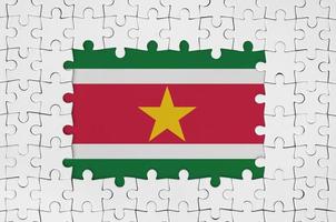 Suriname flag in frame of white puzzle pieces with missing central part photo