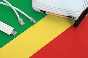 Congo flag depicted on table with internet rj45 cable, wireless usb wifi adapter and router. Internet connection concept photo