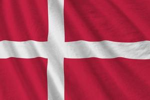 Denmark flag with big folds waving close up under the studio light indoors. The official symbols and colors in banner photo