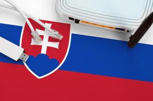Slovakia flag depicted on table with internet rj45 cable, wireless usb wifi adapter and router. Internet connection concept photo