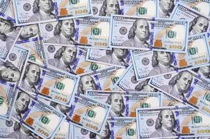 A large number of US dollar bills of a new design with a blue stripe in the middle. Top view photo
