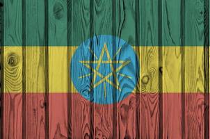 Ethiopia flag depicted in bright paint colors on old wooden wall. Textured banner on rough background photo