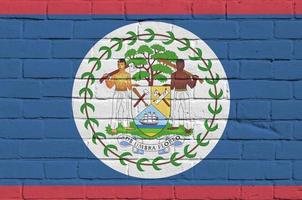 Belize flag depicted in paint colors on old brick wall. Textured banner on big brick wall masonry background photo