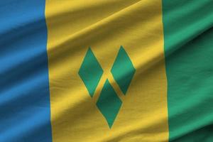 Saint Vincent and the Grenadines flag with big folds waving close up under the studio light indoors. The official symbols and colors in banner photo