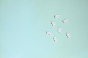 A few chewing gums lie on texture background of fashion pastel blue color paper in minimal concept photo