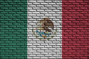 Mexico flag is painted onto an old brick wall photo