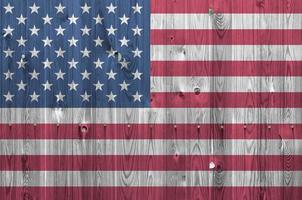 bandera de los estados unidos de américa representada en colores de pintura brillante en la pared de madera vieja. banner texturizado sobre fondo áspero foto
