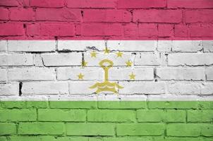 Tajikistan flag is painted onto an old brick wall photo