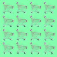 Shopping addiction, shopping lover or shopaholic concept. Many small empty shopping carts perform a pattern on a pastel colored paper background. Flat lay composition, top view photo