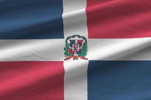 Dominican Republic flag with big folds waving close up under the studio light indoors. The official symbols and colors in banner photo