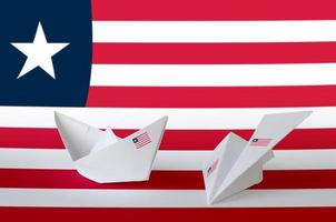 Liberia flag depicted on paper origami airplane and boat. Handmade arts concept photo