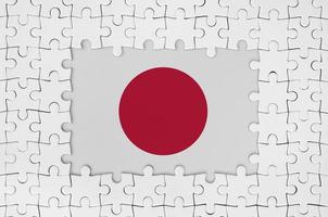 Japan flag in frame of white puzzle pieces with missing central part photo