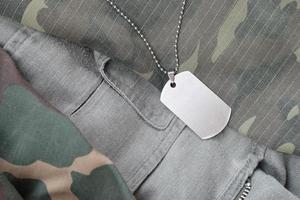 Silvery military beads with dog tag on different camouflage fatigue uniforms photo