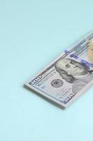 US dollar bills of a new design with a blue stripe in the middle is lies on a light blue background photo