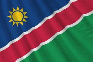 Namibia flag with big folds waving close up under the studio light indoors. The official symbols and colors in banner photo