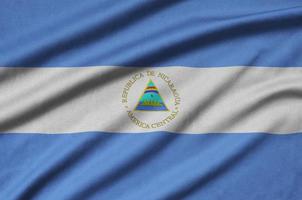 Nicaragua flag  is depicted on a sports cloth fabric with many folds. Sport team banner photo