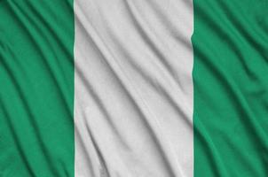 Nigeria flag  is depicted on a sports cloth fabric with many folds. Sport team banner photo