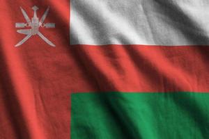 Oman flag with big folds waving close up under the studio light indoors. The official symbols and colors in banner photo