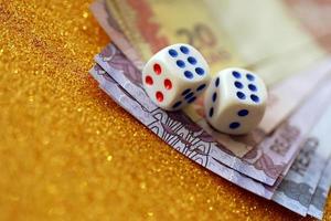 Dice cubes with Brazilian money bills on golden glitter background. Concept of luck and gambling in Brazil photo