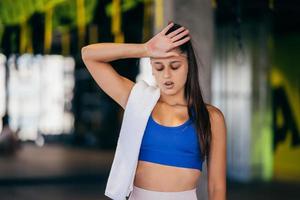 Healthy young female relaxed after training in gym. photo