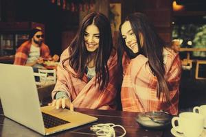 dos chicas viendo algo en la computadora portátil foto