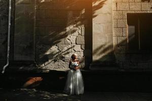 bride posing on stone wall background photo