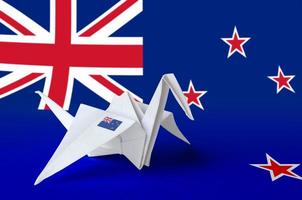 New Zealand flag depicted on paper origami crane wing. Handmade arts concept photo