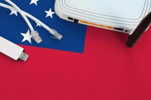 Samoa flag depicted on table with internet rj45 cable, wireless usb wifi adapter and router. Internet connection concept photo