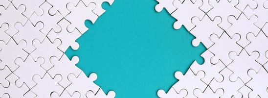 Framing in the form of a rhombus, made of a white jigsaw puzzle around the blue space photo