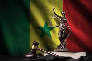 Senegal flag with statue of lady justice, constitution and judge hammer on black drapery. Concept of judgement and guilt photo