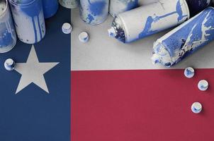 bandera del estado de texas us y pocas latas de aerosol usadas para pintar graffiti. concepto de cultura de arte callejero foto