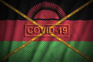 Malawi flag and Covid-19 stamp with orange quarantine border tape cross. Coronavirus or 2019-nCov virus concept photo