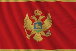 Montenegro flag with big folds waving close up under the studio light indoors. The official symbols and colors in banner photo