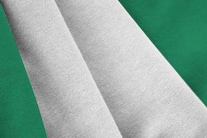 Nigeria flag with big folds waving close up under the studio light indoors. The official symbols and colors in banner photo