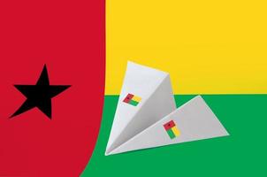 Guinea Bissau flag depicted on paper origami airplane. Handmade arts concept photo
