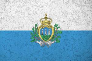 San Marino flag depicted in bright paint colors on old relief plastering wall. Textured banner on rough background photo