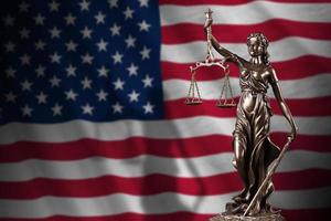 United States of America flag with statue of lady justice and judicial scales in dark room. Concept of judgement and punishment photo