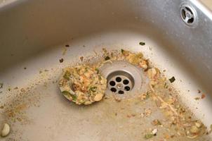 Close up on dirty clogging kitchen sink drain with food particles photo